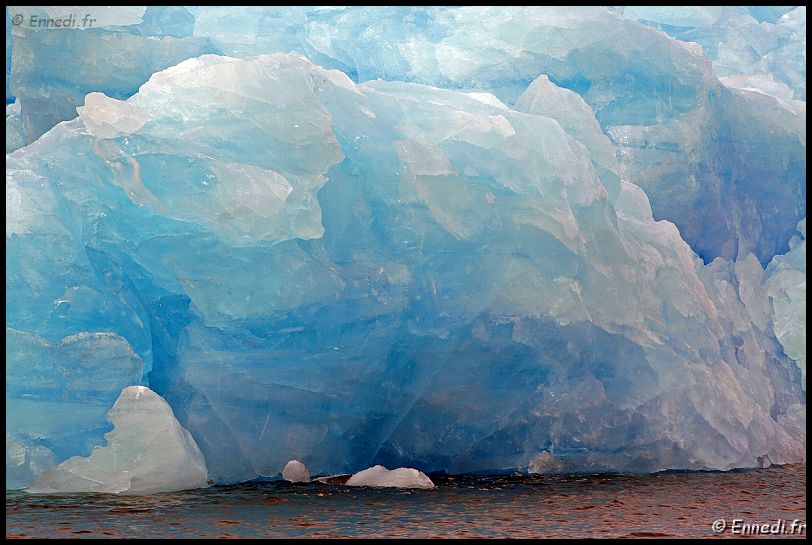 spitzberg_6831a.jpg - KongsFordjen. Iceberg en glace bleue. La mer est rouge à cause du limon arraché par les glaciers.